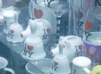 An array of porcelain "I love New York" merch displayed on a storefront shelf in a gift shop in Manhattan.